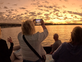 A group of friends captures a stunning sunset from their boat, creating unforgettable memories during a picturesque evening on the water.