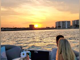 A couple enjoys a romantic sunset view from their boat, creating a perfect backdrop for memorable moments on the water.