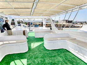 A spacious lounge area on a boat featuring comfortable seating and a relaxing atmosphere, perfect for enjoying time on the water.