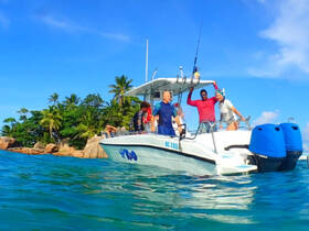 A lively group enjoys a day on the water, celebrating aboard a boat near a tropical island — perfect for unforgettable adventures and fun in the sun.