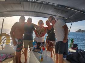 A cheerful group enjoys a memorable moment aboard a boat, celebrating together against a stunning ocean backdrop.