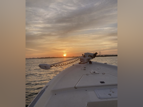 A serene sunset view from the bow of a boat, showcasing the tranquil waters and the silhouette of the horizon — perfect for evening cruises.