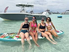 A group of friends enjoys a fun day paddleboarding in clear waters, showcasing the perfect beach outing with laughter and relaxation.