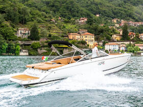 A stylish boat cruises through scenic waters, showcasing beautiful hillside homes in the background — perfect for exploring picturesque destinations.