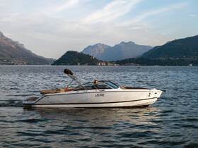 A sleek speedboat glides across the serene waters, framed by stunning mountain scenery — perfect for exploring lakes or enjoying a day on the water.