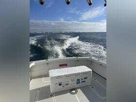 A view from the back of a boat showcasing a cooler on the deck, with a scenic backdrop of the coastline and waves in motion — perfect for a day out on the water.