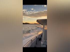 A scenic view of a boat cruising through calm waters at sunset, showcasing the beautiful sky and the vessel's sleek design.