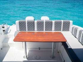 A stylish dining area on a boat featuring comfortable seating and a polished wooden table, perfect for enjoying meals while cruising on turquoise waters.