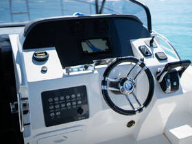 A close-up view of a modern boat helm featuring a sleek steering wheel and control panel, perfect for navigating the open waters.
