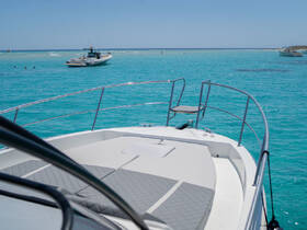 A stunning view from the bow of a boat, showcasing the vibrant turquoise waters and nearby vessels, perfect for a day of adventure on the water.