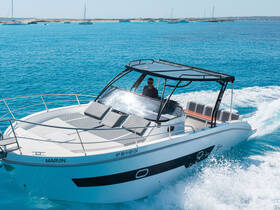 A sleek speedboat named 'Marvin' glides through the vibrant turquoise waters, showcasing its stylish design and comfortable seating.
