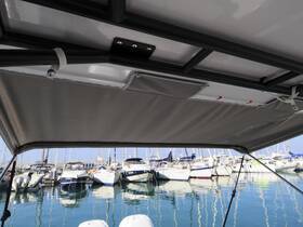 View from inside a boat's shaded area, showcasing the bimini top and a marina filled with various vessels in the background.
