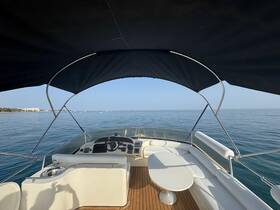 A view of the helm area inside a boat, showcasing the seating and dashboard, perfect for a relaxing day on the water.