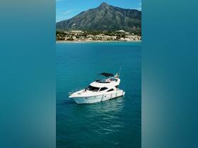 A stunning aerial view of a yacht cruising through clear turquoise waters, with a picturesque mountain backdrop, perfect for luxury boating experiences.