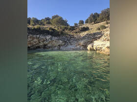 A stunning view of a secluded coastline with crystal-clear waters, perfect for exploring hidden beaches and enjoying nature's beauty.