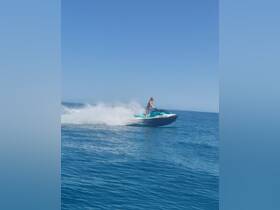 A thrilling moment captured as a person rides a jet ski across the sparkling blue waters, showcasing the excitement of water sports.