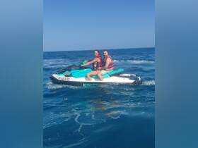 A couple enjoys an exhilarating ride on a jet ski, capturing the thrill of water sports in the open sea.