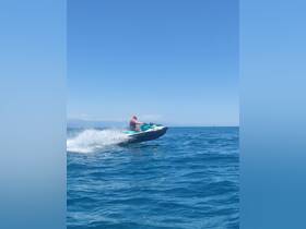 A thrilling moment captured as a rider jumps a jet ski over the waves, showcasing the excitement of water sports in a beautiful ocean setting.