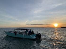 A group enjoys a scenic sunset cruise aboard a boat, creating a perfect backdrop for memorable moments on the water.