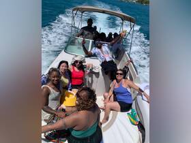 A lively group enjoys a fun day on the water, celebrating aboard a boat with drinks and laughter — perfect for unforgettable outings with friends.