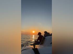 A family enjoys a serene sunset on the water, creating a perfect backdrop for memorable moments aboard their boat.
