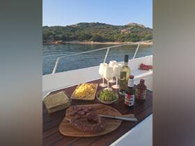 A beautifully arranged charcuterie spread featuring meats, cheeses, and drinks on a boat, perfect for a relaxing day on the water.