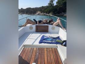 A group of friends relaxes on the deck of a boat, enjoying the sun and beautiful surroundings — perfect for a day of leisure on the water.