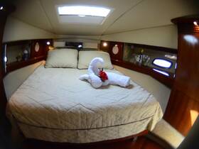 Cozy cabin interior featuring a neatly made bed with decorative towel art, perfect for relaxing on a boat getaway.
