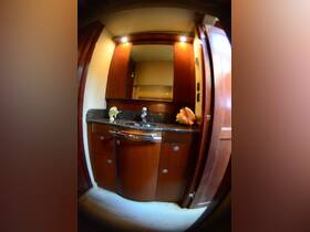 Interior view of a boat bathroom featuring elegant wooden cabinetry and a stylish sink, showcasing the comfort and luxury of onboard amenities.