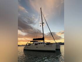 A stunning catamaran named 'Good Medicine' is docked against a vibrant sunset backdrop, showcasing the beauty of sailing adventures.