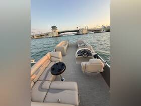 Interior view of a spacious pontoon boat featuring comfortable seating and a helm, perfect for relaxing on the water.