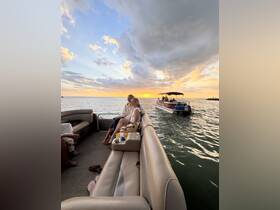A couple enjoys a romantic sunset aboard a pontoon boat, creating the perfect atmosphere for special moments on the water.