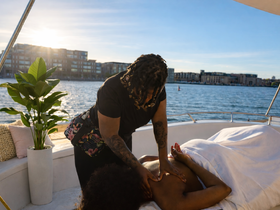 A serene moment on a boat as a massage therapist provides relaxation by the water, perfect for unwinding during a luxurious boating experience.