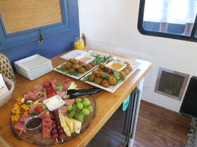 A beautifully arranged charcuterie board alongside delicious appetizers, perfect for onboard dining experiences. Enjoy gourmet snacks while cruising on the water.