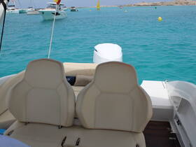 Interior view of a boat's seating area, showcasing comfortable helm chairs against a backdrop of turquoise waters — perfect for relaxing while cruising.
