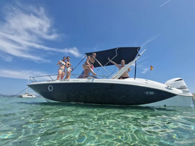 A lively group of friends enjoys a fun day on the water, celebrating aboard a boat in crystal-clear waters — perfect for summer adventures.