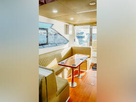 Interior view of a stylish boat cabin featuring comfortable seating and a dining area, perfect for relaxing and enjoying meals while on the water.