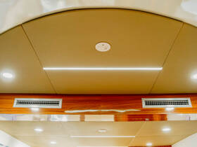 A close-up view of the ceiling inside a boat cabin, featuring modern lighting and air vents, showcasing the elegant interior design.