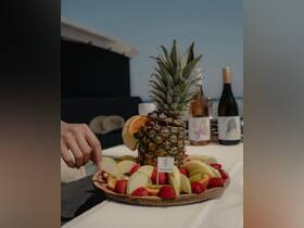 A beautifully arranged fruit platter featuring a pineapple centerpiece, perfect for enjoying refreshing snacks while yachting. Ideal for catering on luxury boat trips.