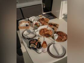 A beautifully arranged table featuring a variety of gourmet dishes and drinks, perfect for dining aboard a boat. Ideal for showcasing onboard catering options.