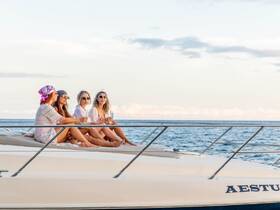 A group of friends enjoys cocktails on the deck of a yacht, capturing the essence of a perfect sunset cruise — ideal for celebrations and memorable outings on the water.