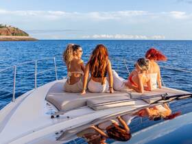 A group of friends enjoys a relaxing moment on the deck of a yacht, soaking in the beautiful ocean views — perfect for memorable outings and sunset cruises.