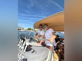 Two friends enjoy a sunny day on the water, taking the helm of their boat — perfect for a fun day out with friends.