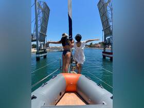 Two friends enjoy a sunny day on a sailboat, celebrating their adventure with arms outstretched, capturing the joy of sailing together.
