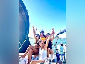A joyful group of friends celebrates on a yacht, showcasing the perfect atmosphere for a fun day on the water with laughter and camaraderie.