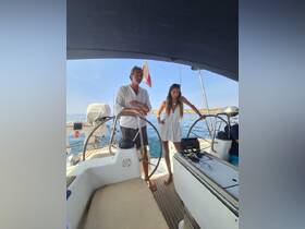 Two individuals stand at the helm of a sailboat, showcasing the interior space and steering area, perfect for navigating the open waters.