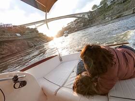 A serene moment as a couple relaxes on a boat during sunset, creating a perfect backdrop for romantic outings or family adventures on the water.