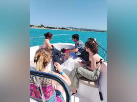 A group of friends enjoys a sunny day on a boat, capturing the essence of fun and relaxation on the water.