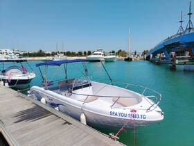 A sleek boat named 'SEA YOU' docked at a marina, surrounded by clear turquoise waters and other vessels, perfect for a day out on the water.
