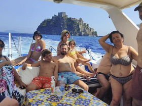 A joyful group enjoys a sunny day on a boat, with a picturesque island backdrop — perfect for family outings and memorable adventures on the water.